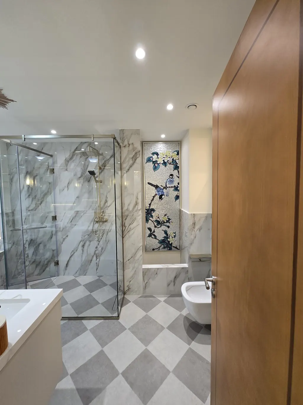 Bathroom with a glass shower, chequered floor and marble-look walls