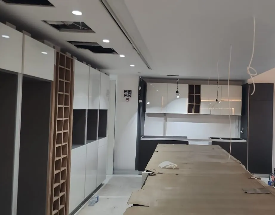 Open-plan room with the coffered ceiling frames up and the kitchen run in place
