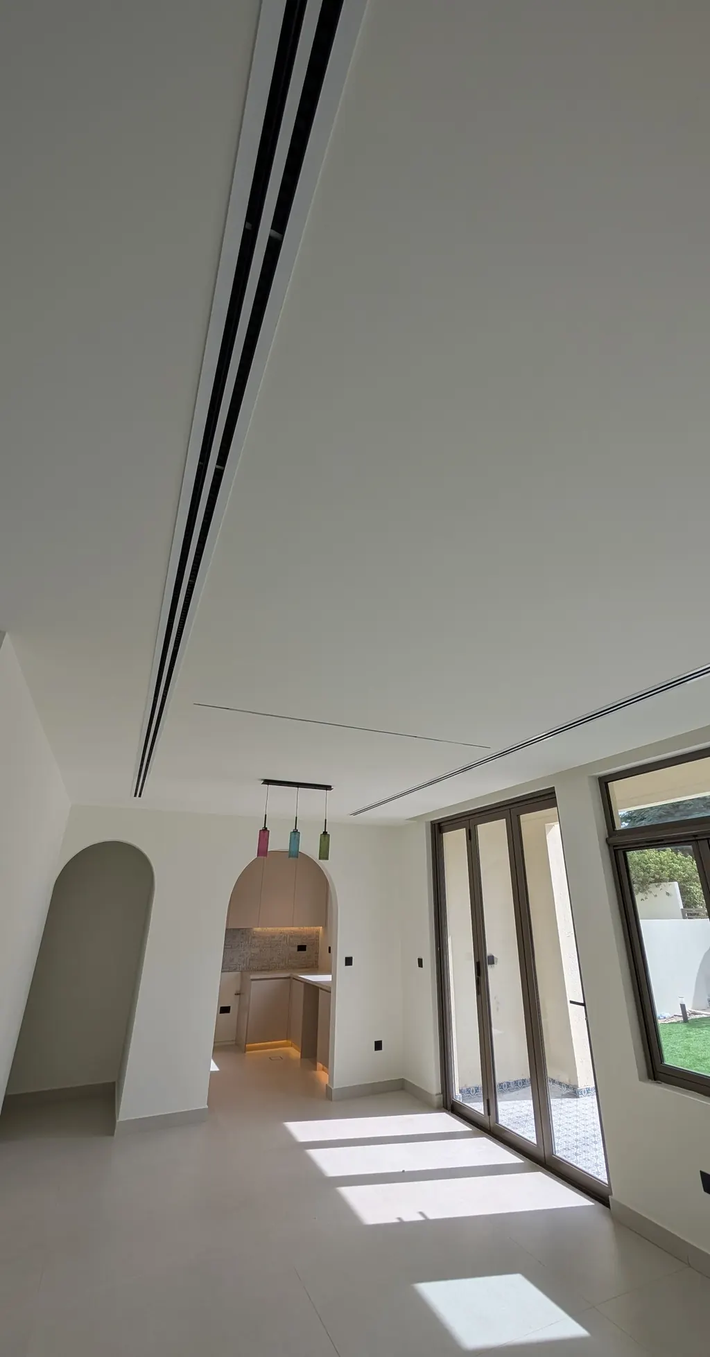 Living room with an arched opening and slot diffusers in the ceiling
