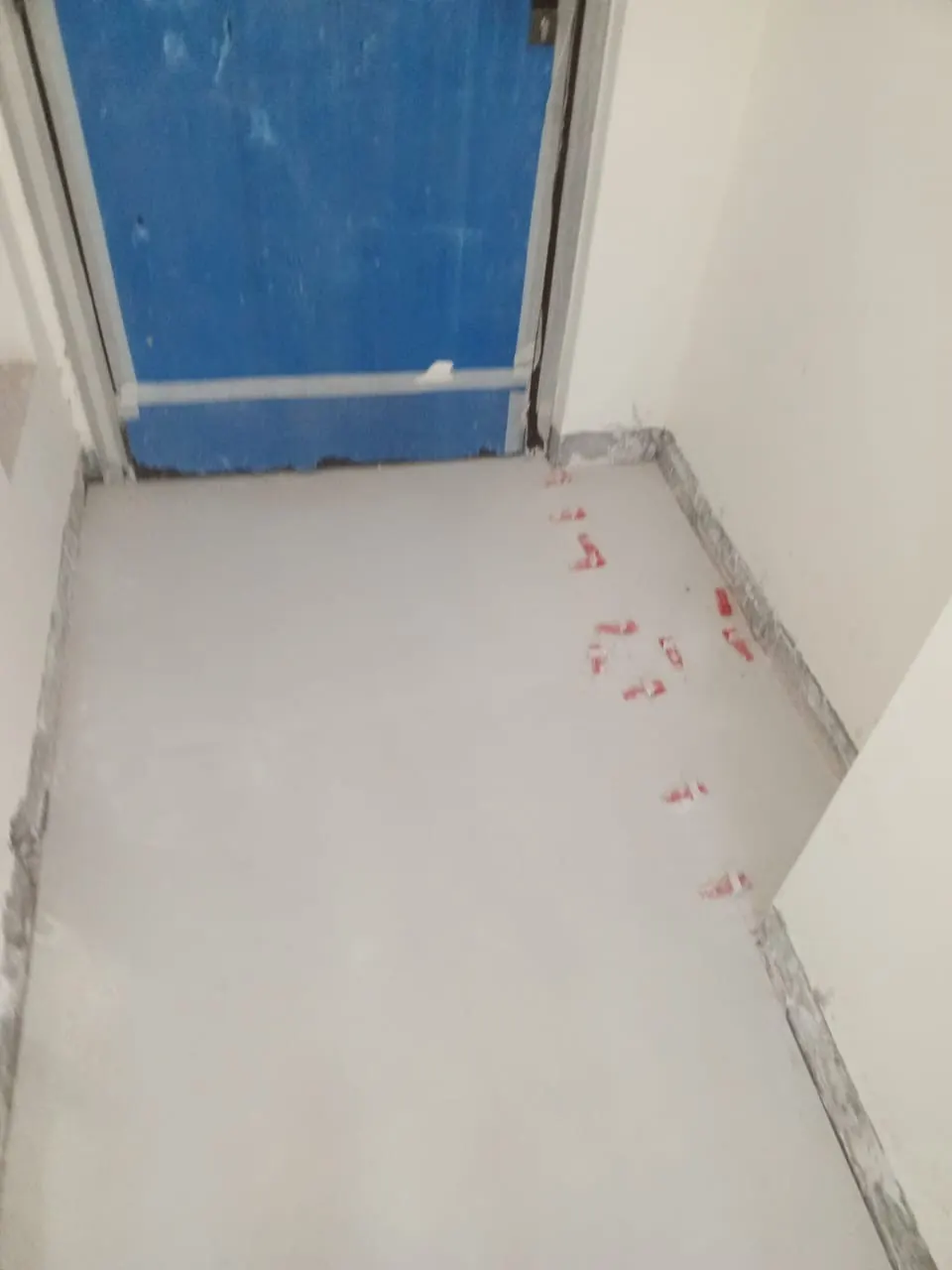 New floor tile laid in the hall, spacers still in the joints